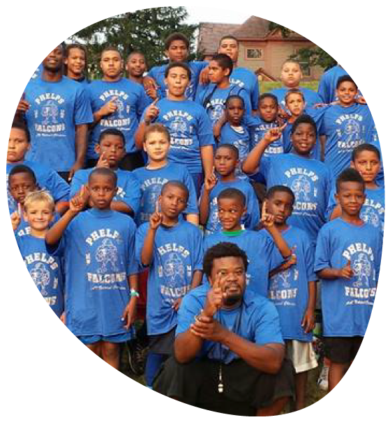 A group of kids part of the Phelps Falcons posing together and wearing matching light blue t-shirts.